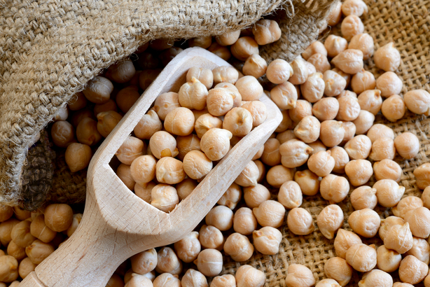 Extracción de garbanzos de un saco con una cuchara de madera 